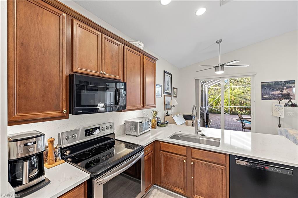 227 Glen Eagle Circle Naples, FL 34104 - Photo 4 of 25 a kitchen with a stove a sink and a microwave