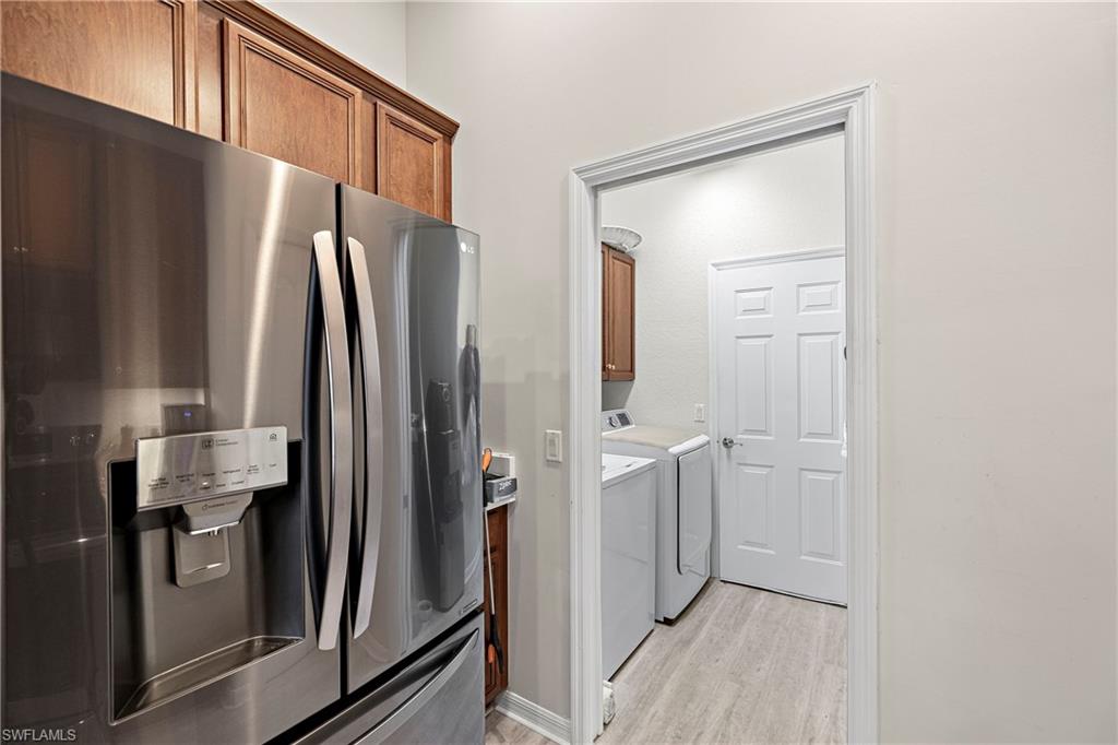 227 Glen Eagle Circle Naples, FL 34104 - Photo 8 of 25 a view of hallway with stainless steel appliances a refrigerator and cabinets