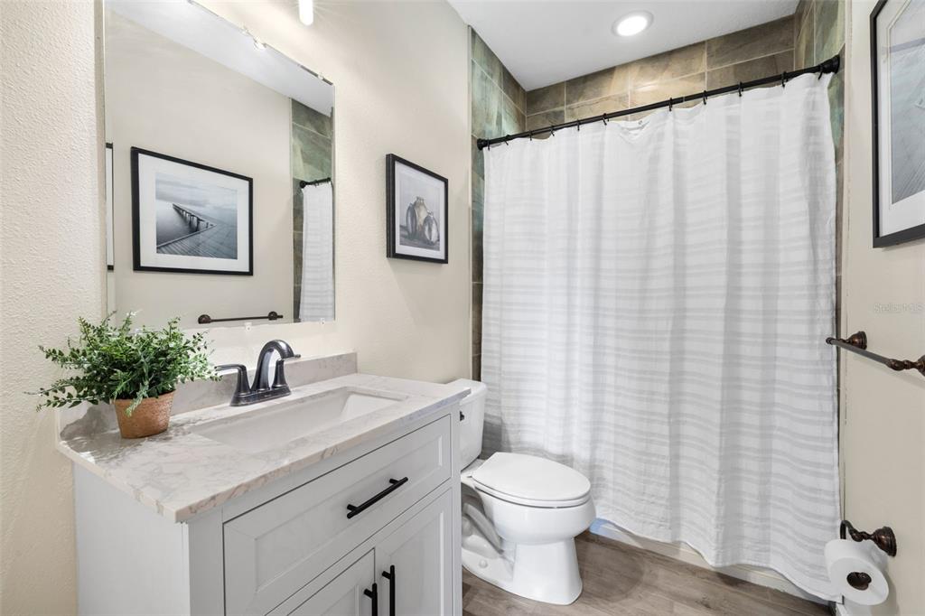 14765 Highway 41 Spring Hill, FL 34610 - Photo 16 of 61 a bathroom with a sink a toilet and shower curtain