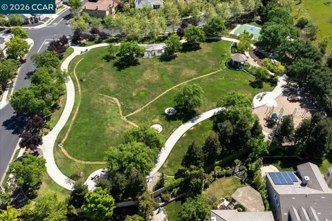 an aerial view of residential houses with outdoor space and trees