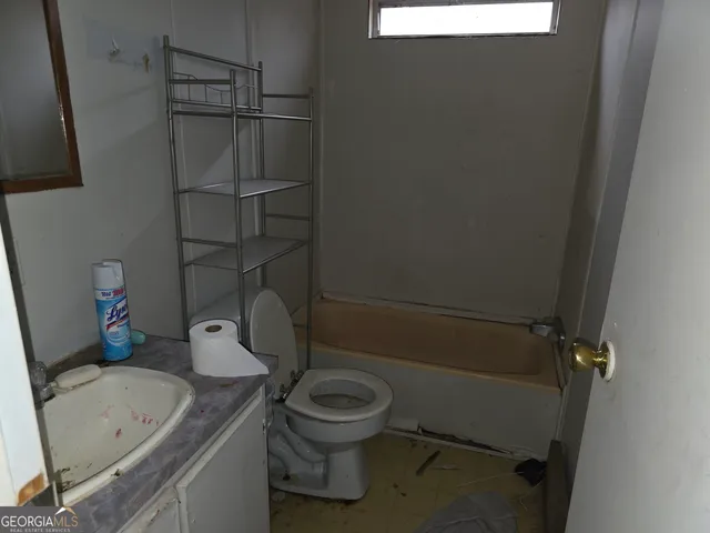 a view of an empty room with wooden floor and closet