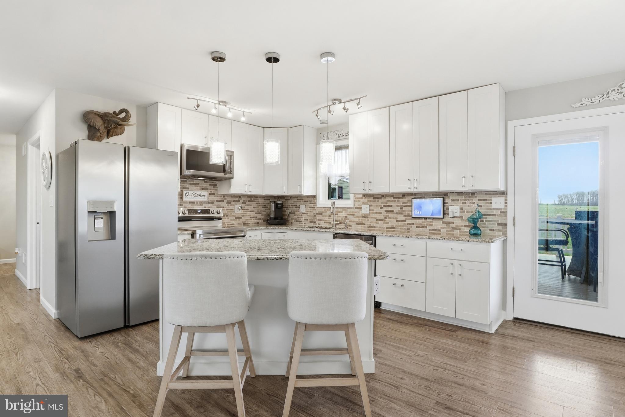 1025 White Oak Road Windsor, PA 17366 - Photo 10 of 70 a kitchen with stainless steel appliances granite countertop a refrigerator a sink dishwasher a stove a dining table and chairs with wooden floor
