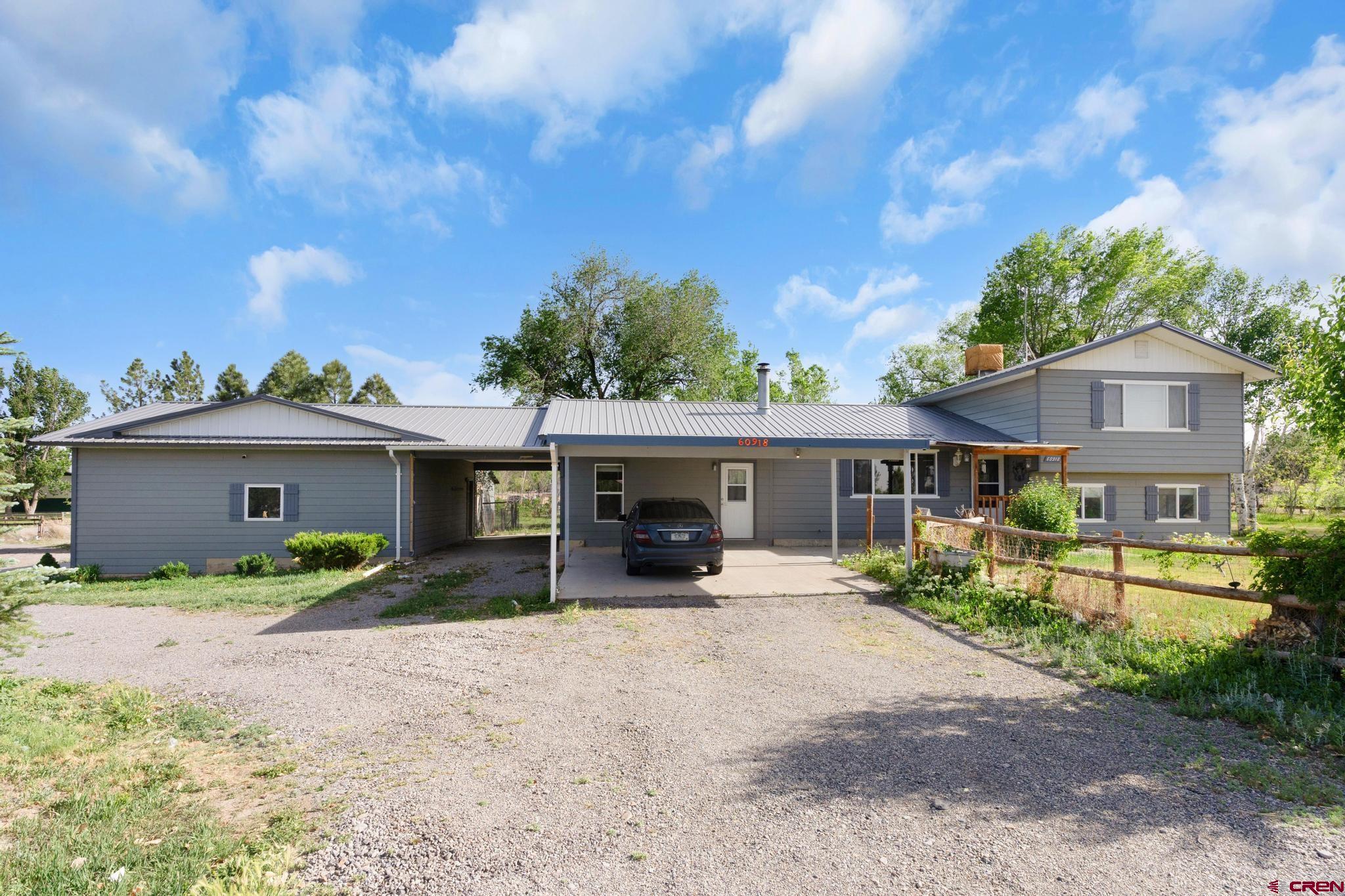a view of a house with a yard and large tree