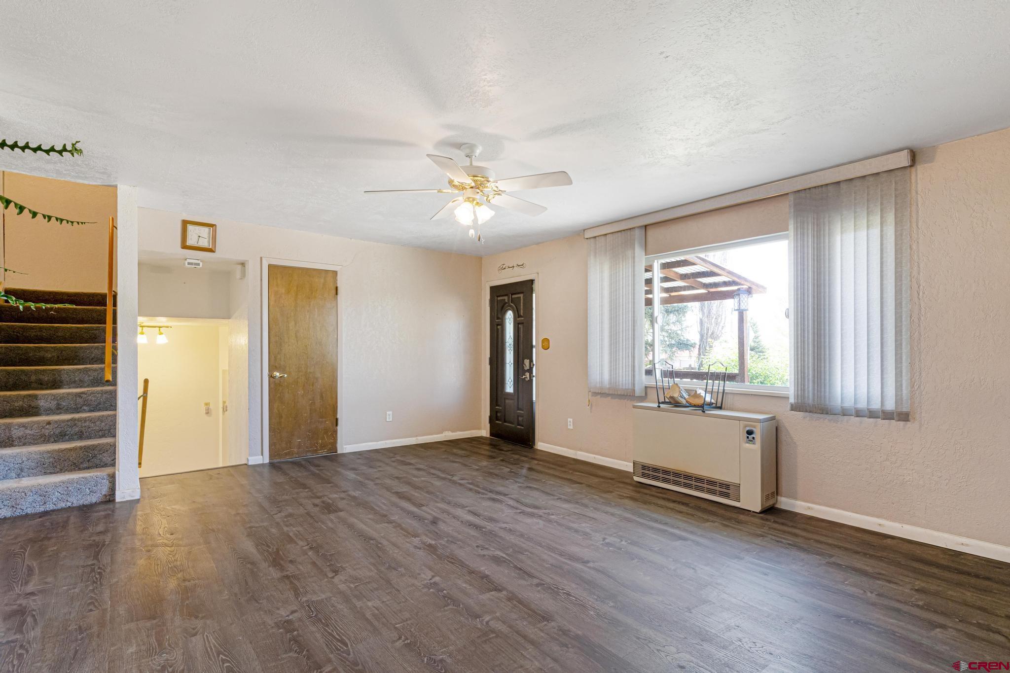60918 Gunnison Road Montrose, CO 81401 - Photo 13 of 37 an empty room with wooden floor cabinet and windows