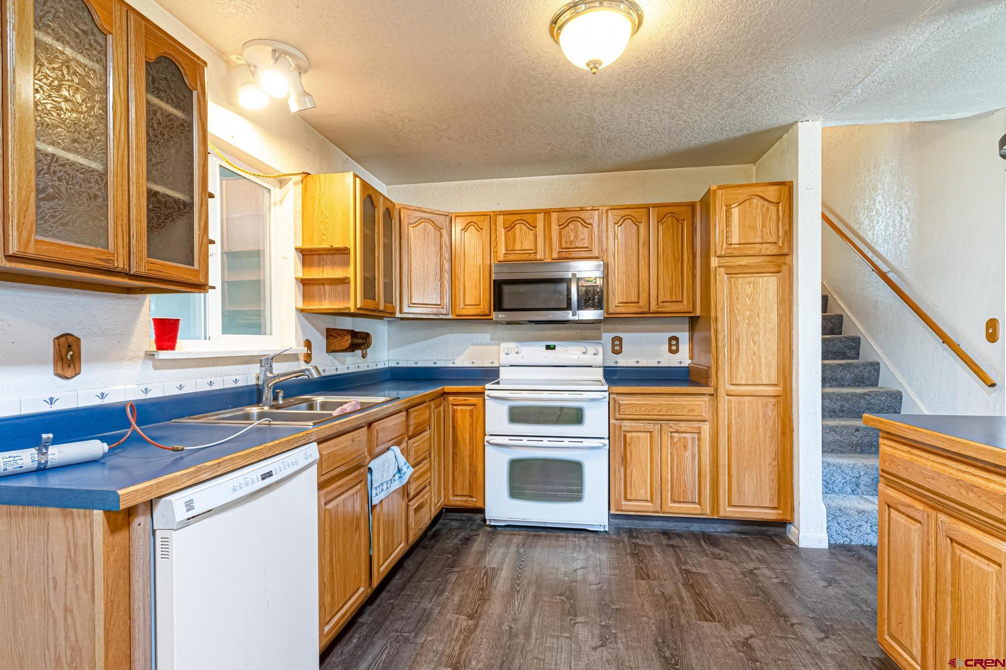 60918 Gunnison Road Montrose, CO 81401 - Photo 16 of 37 a kitchen with stainless steel appliances granite countertop a stove a sink dishwasher and a microwave oven with cabinets