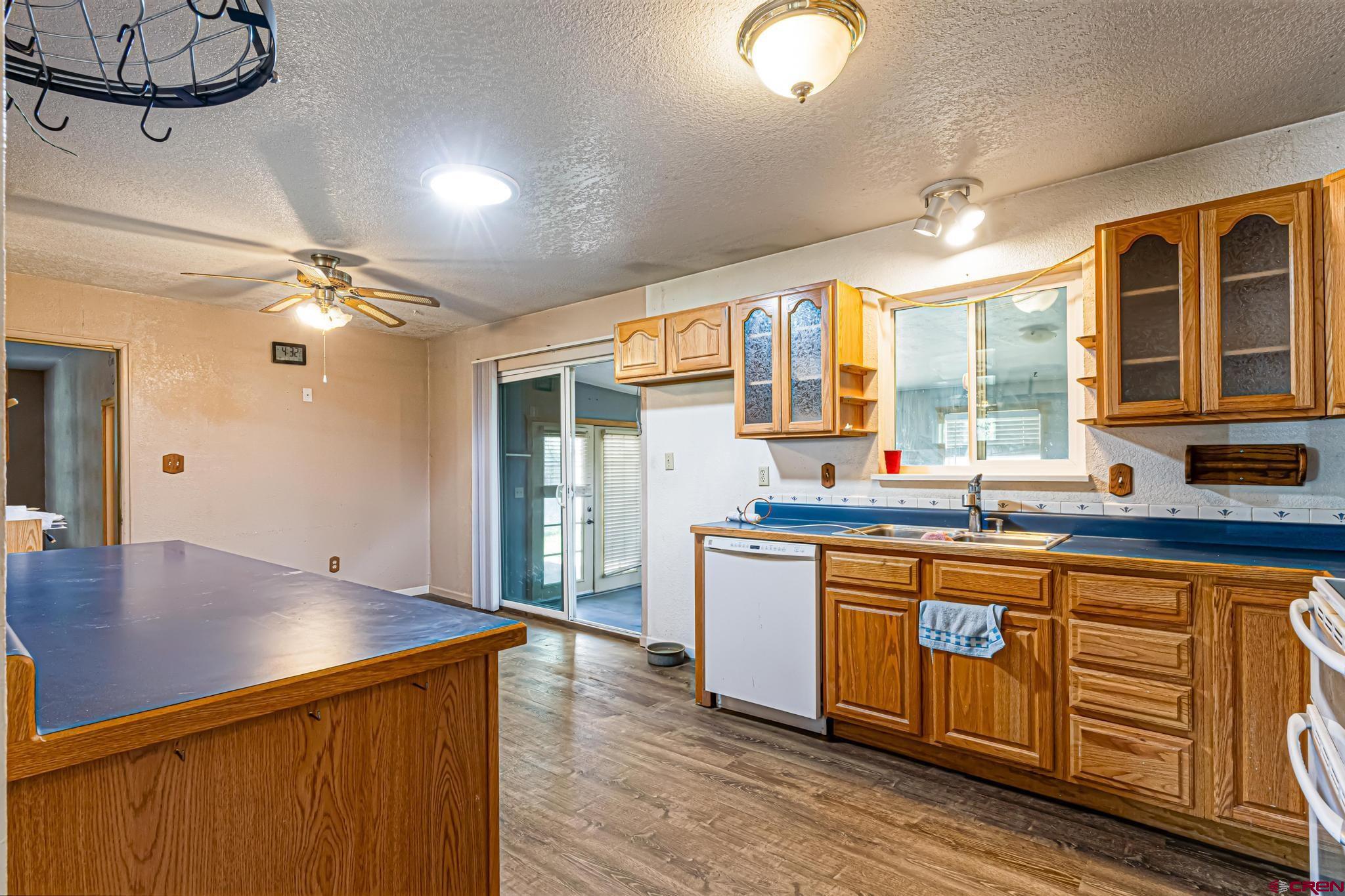 60918 Gunnison Road Montrose, CO 81401 - Photo 17 of 37 a kitchen with stainless steel appliances granite countertop a sink cabinets and wooden floor