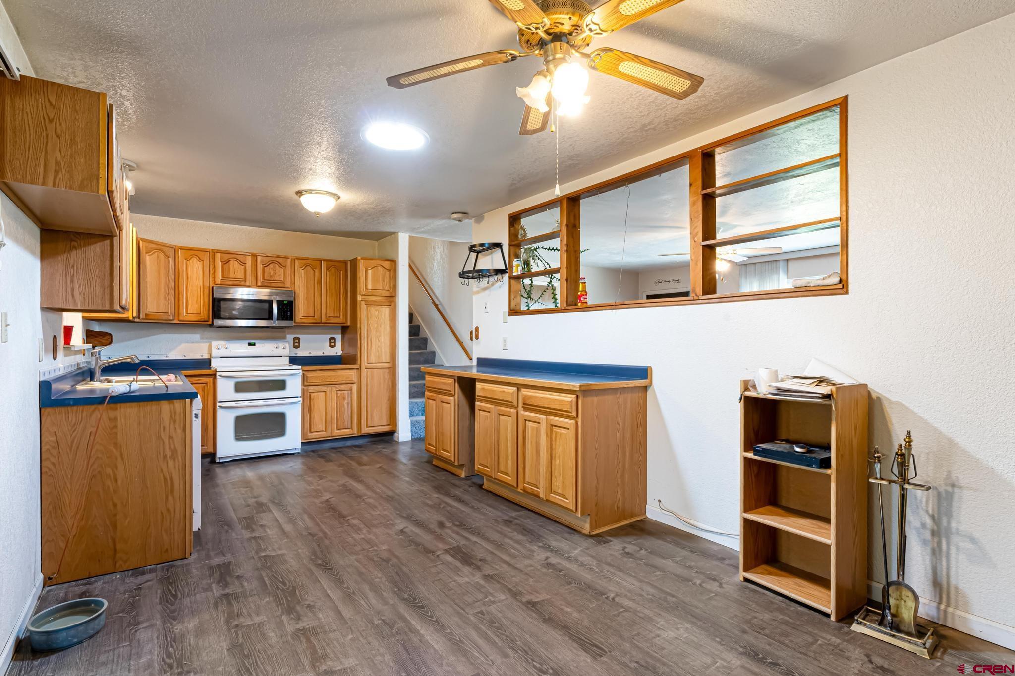 60918 Gunnison Road Montrose, CO 81401 - Photo 18 of 37 a kitchen with stainless steel appliances kitchen island granite countertop a stove and a refrigerator
