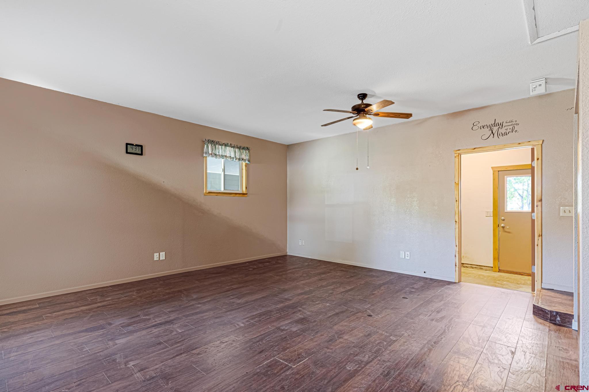 60918 Gunnison Road Montrose, CO 81401 - Photo 20 of 37 a view of an empty room with window and wooden floor
