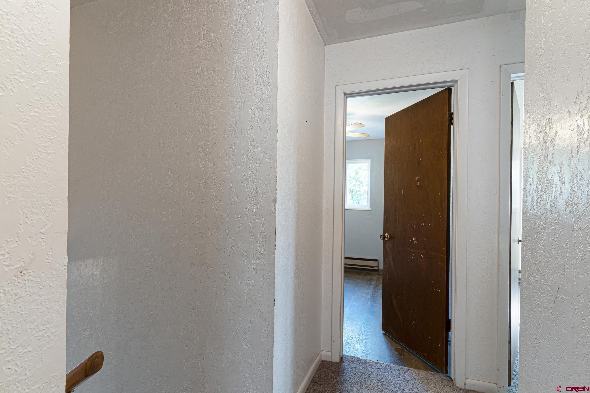 60918 Gunnison Road Montrose, CO 81401 - Photo 27 of 37 a view of a bathroom from a hallway with wooden floor