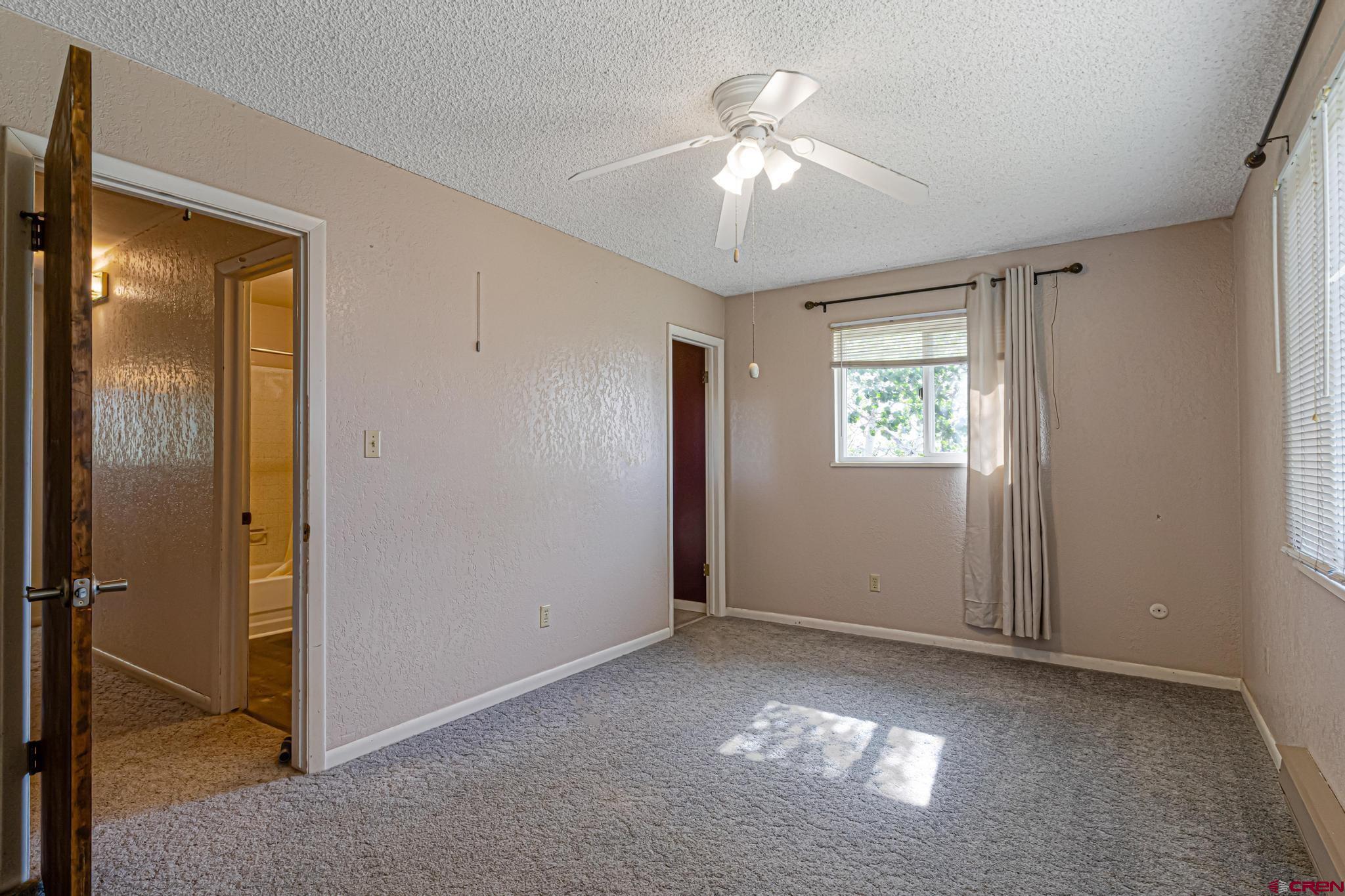 60918 Gunnison Road Montrose, CO 81401 - Photo 28 of 37 a view of an empty room with window and chandelier fan