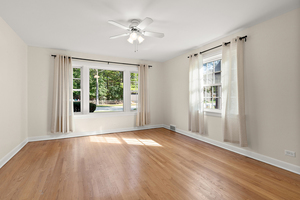 372 Stratford Road Des Plaines, IL 60016 - Photo 9 of 13 a view of an empty room with a window and wooden floor