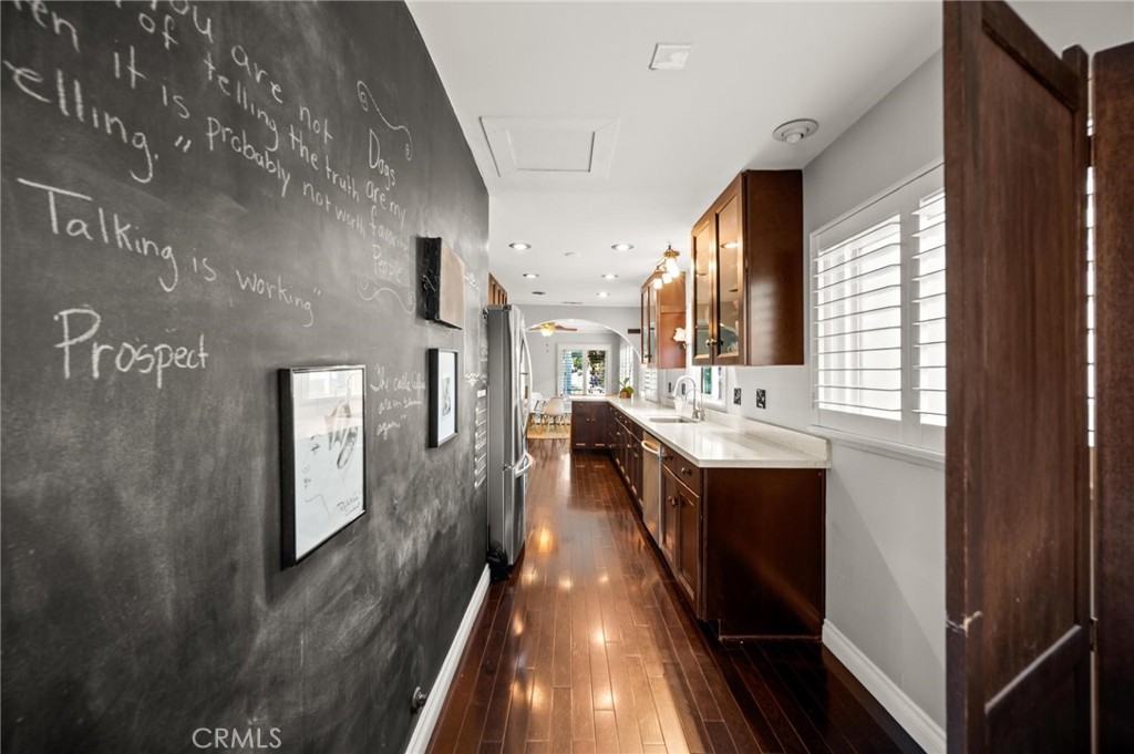 3441 Virginia Road Los Angeles, CA 90016 - Photo 12 of 40 a kitchen with stainless steel appliances granite countertop a refrigerator a sink dishwasher a stove and white countertops with wooden floor