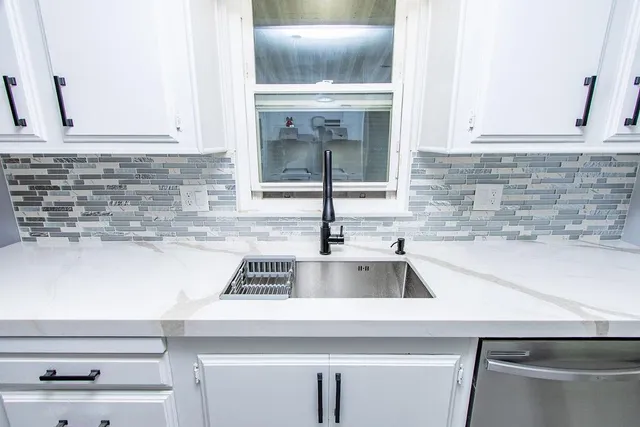 a kitchen with granite countertop a sink and a stove