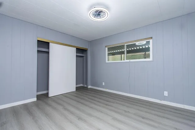 an empty room with wooden floor and window