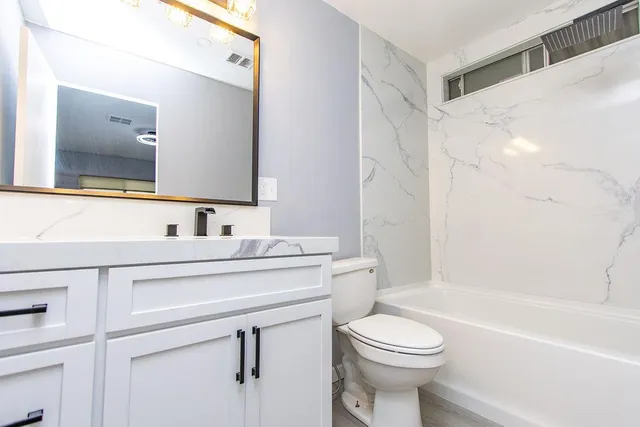 a bathroom with a sink a toilet and a mirror