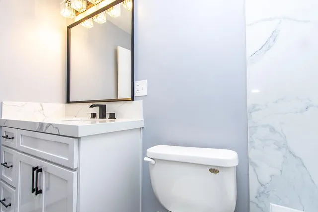 a bathroom with a sink a toilet and mirror