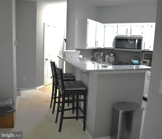 a kitchen with stainless steel appliances a table and chairs in it
