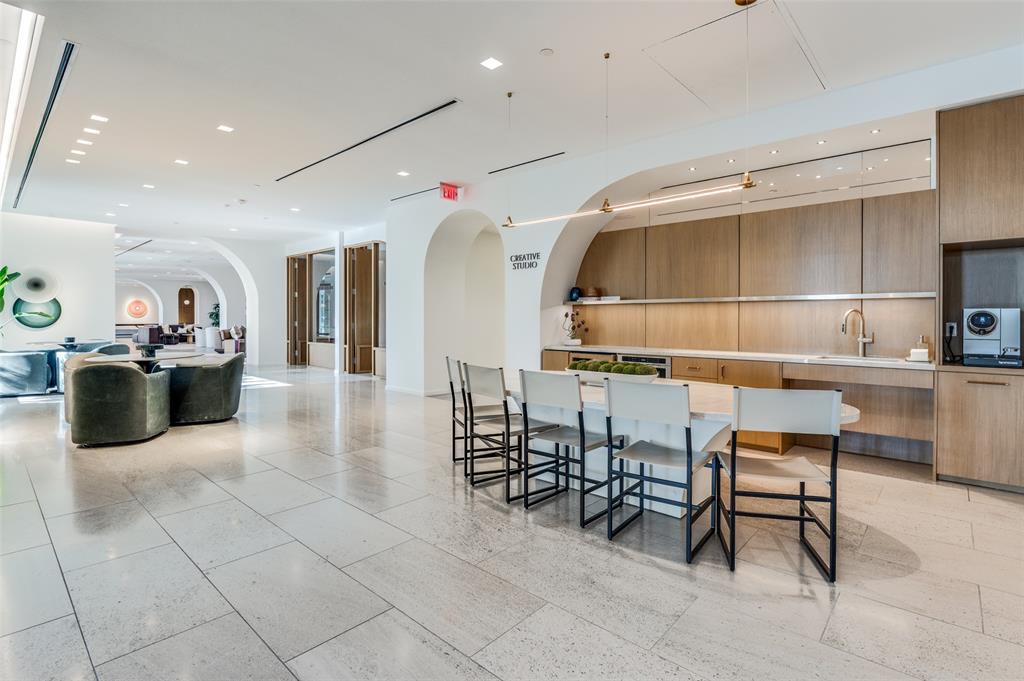 3003 Maple Avenue, Unit 2220 Dallas, TX 75201 - Photo 29 of 40 a kitchen with stainless steel appliances kitchen island granite countertop a table and chairs in it