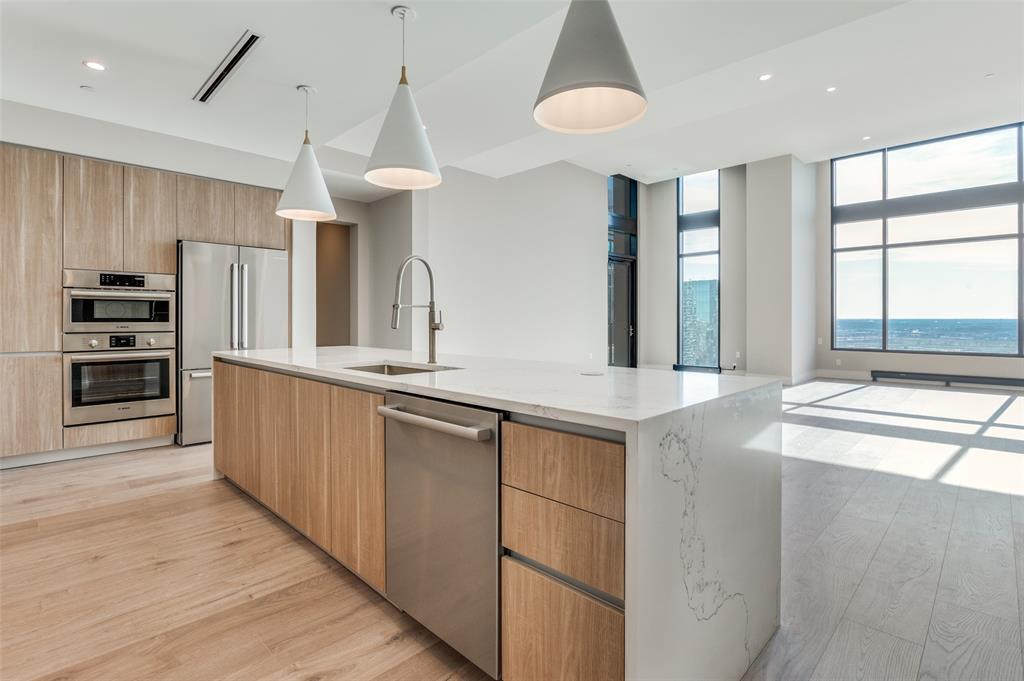 3003 Maple Avenue, Unit 2220 Dallas, TX 75201 - Photo 3 of 40 a large kitchen with stainless steel appliances a large counter top a stove and a sink