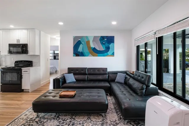 a kitchen with stainless steel appliances a stove a sink a microwave a center island and a refrigerator