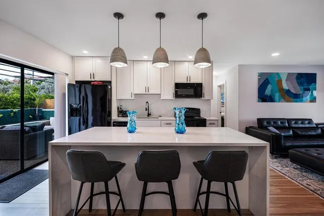 a living room with furniture a flat screen tv and a floor to ceiling window