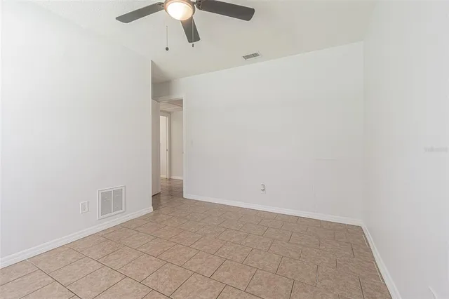 an empty room with a ceiling fan and a window