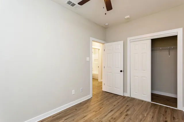 an empty room with ceiling fan and window