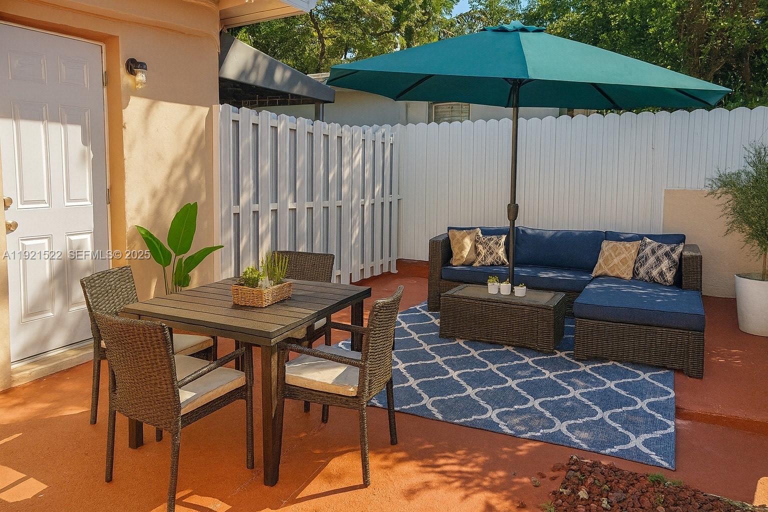 1450 Southwest 6th Street, Unit 1 Miami, FL 33135 - Photo 4 of 7 a view of a backyard with furniture and an umbrella