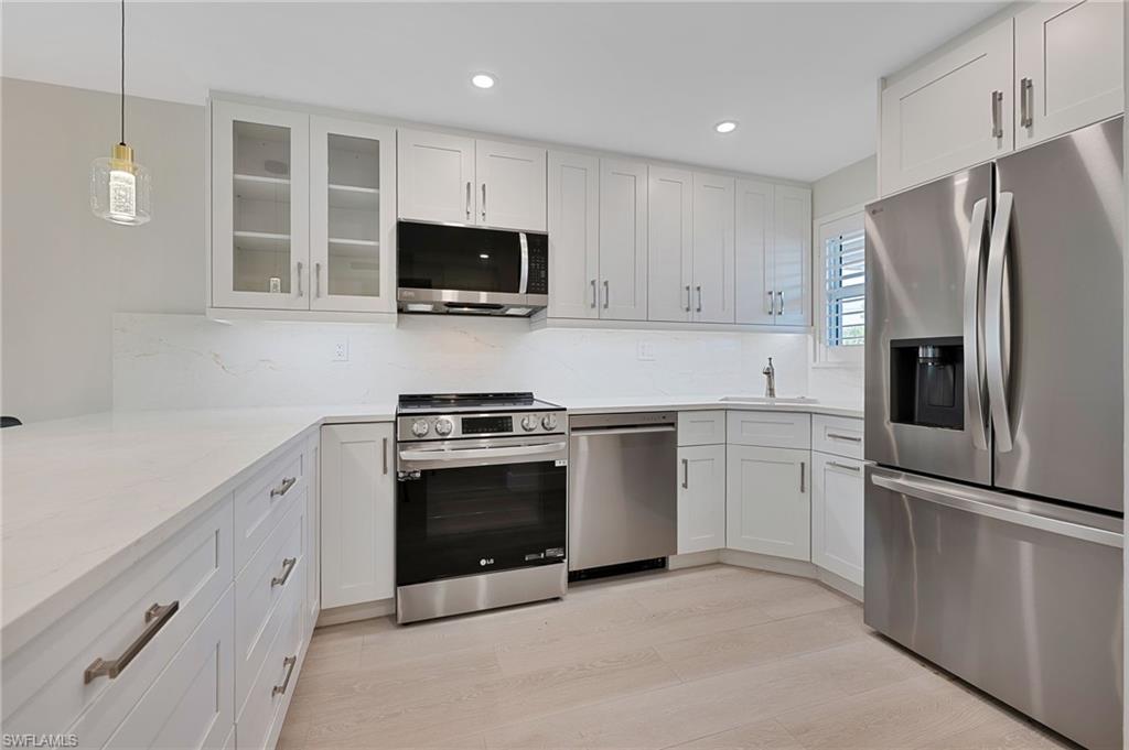 9 High Point Circle North, Unit 108 Naples, FL 34103 - Photo 4 of 17 White Kitchen with SS Appliances