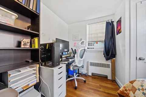 a view of a livingroom with workspace and a window