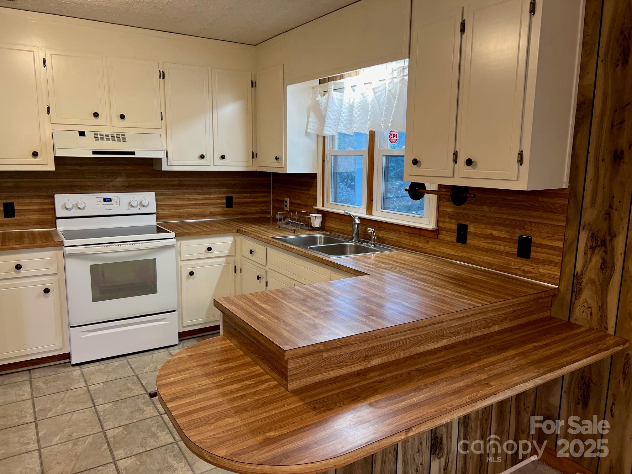 2819 Playmore Beach Road Morganton, NC 28655 - Photo 10 of 30 a kitchen with granite countertop a stove a sink and a refrigerator