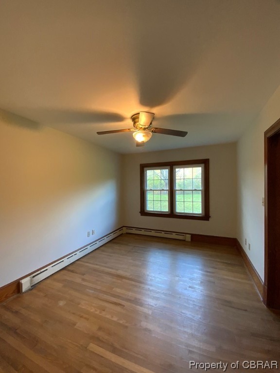 14 Light Street Heathsville, VA 22473 - Photo 8 of 18 Unfurnished room with hardwood / wood-style floors, ceiling fan, and a baseboard radiator
