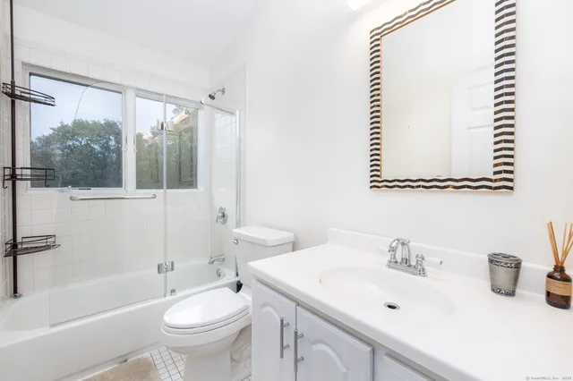 a bathroom with a sink mirror toilet and bathtub
