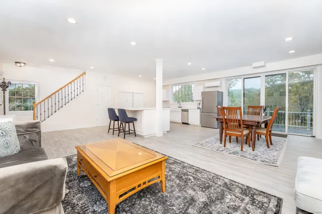 a living room with furniture a rug and a large window