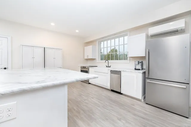 a kitchen with white cabinets and white appliances