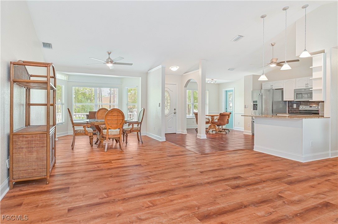 6840 Cadet Avenue Fort Myers, FL 33905 - Photo 19 of 37 a view of a living room and kitchen with furniture and wooden floor