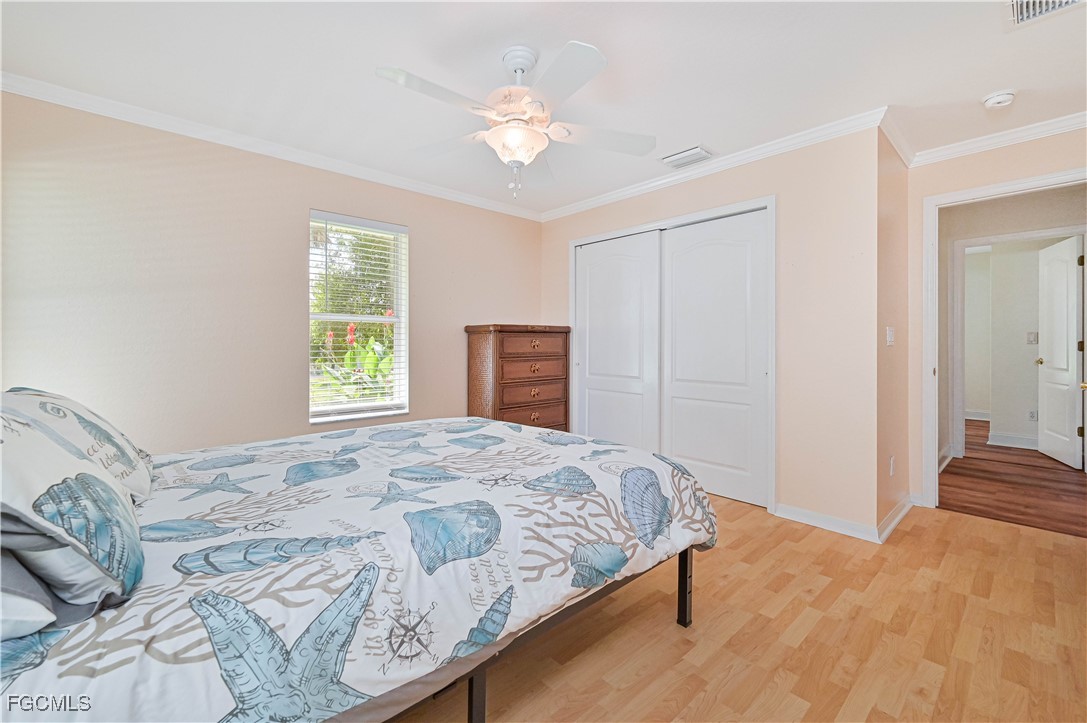 6840 Cadet Avenue Fort Myers, FL 33905 - Photo 35 of 37 a bedroom with a large bed and a chandelier