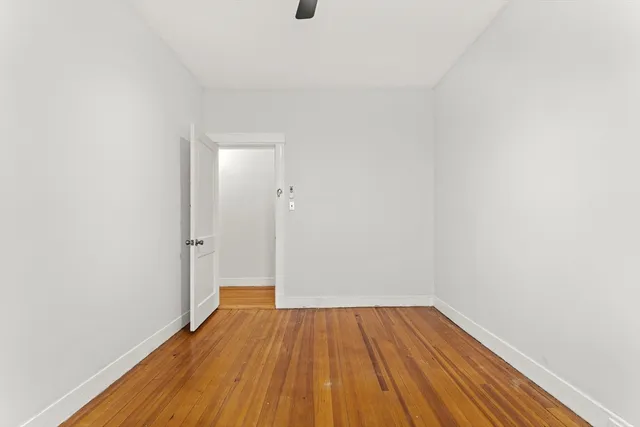 a view of empty room with wooden floor and cabinet