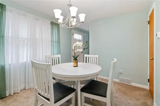 a view of a dining room with furniture wooden floor and chandelier