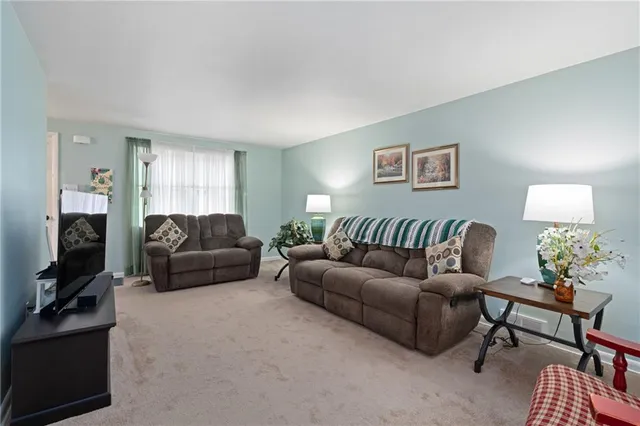 a living room with furniture a flat screen tv and a window