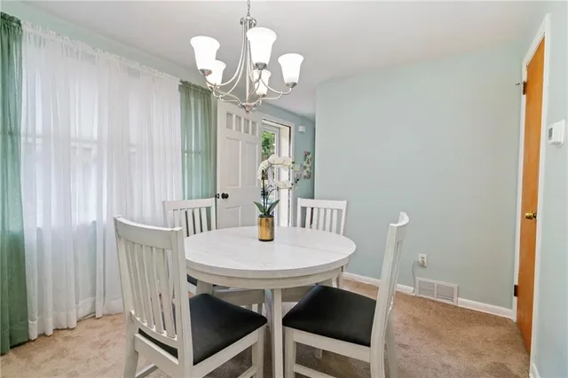 a view of a dining room with furniture and a chandelier