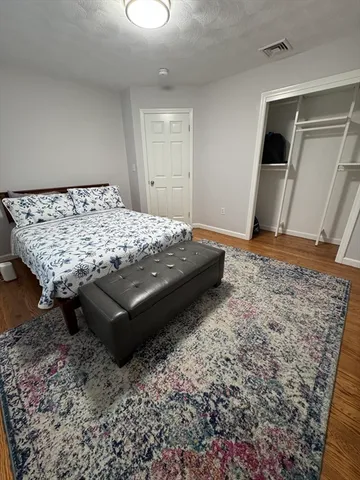 a bed sitting in a spacious bedroom next to a window