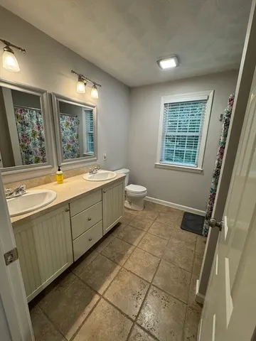 a spacious bathroom with a granite countertop sink toilet and shower