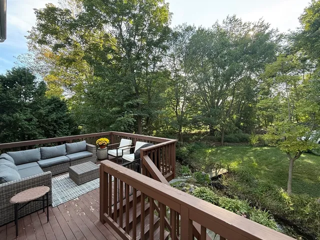 a view of deck with furniture and trees