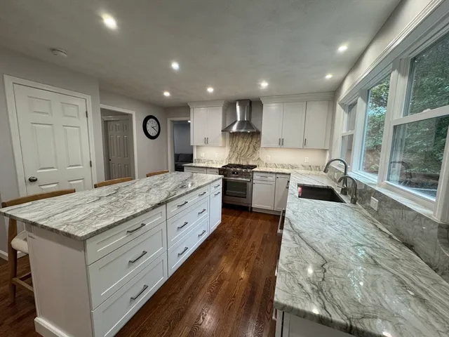a large kitchen with kitchen island a sink stainless steel appliances and cabinets