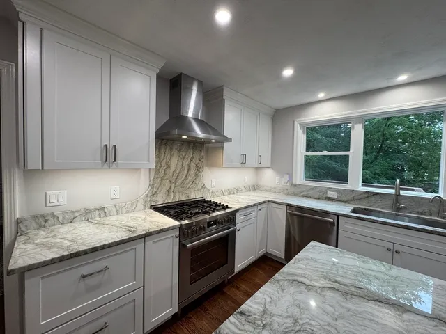 a kitchen with stainless steel appliances granite countertop a stove and a sink