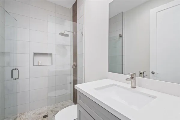 a bathroom with a sink a toilet and shower