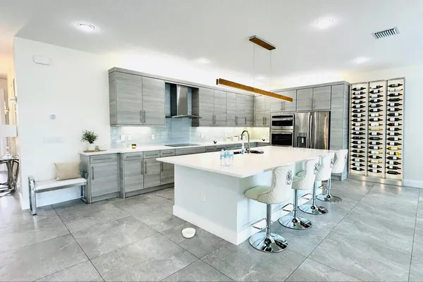 a large white kitchen with a large window and stainless steel appliances