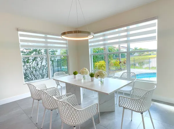 a dining room with furniture a chandelier and wooden floor