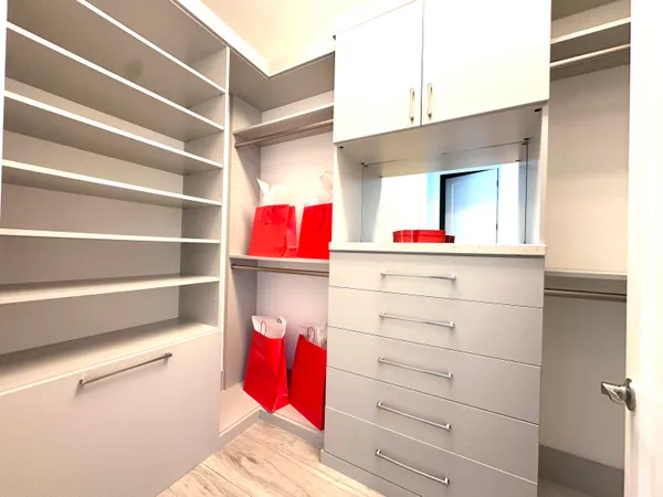 a view of walk in closet with clothes and shoes